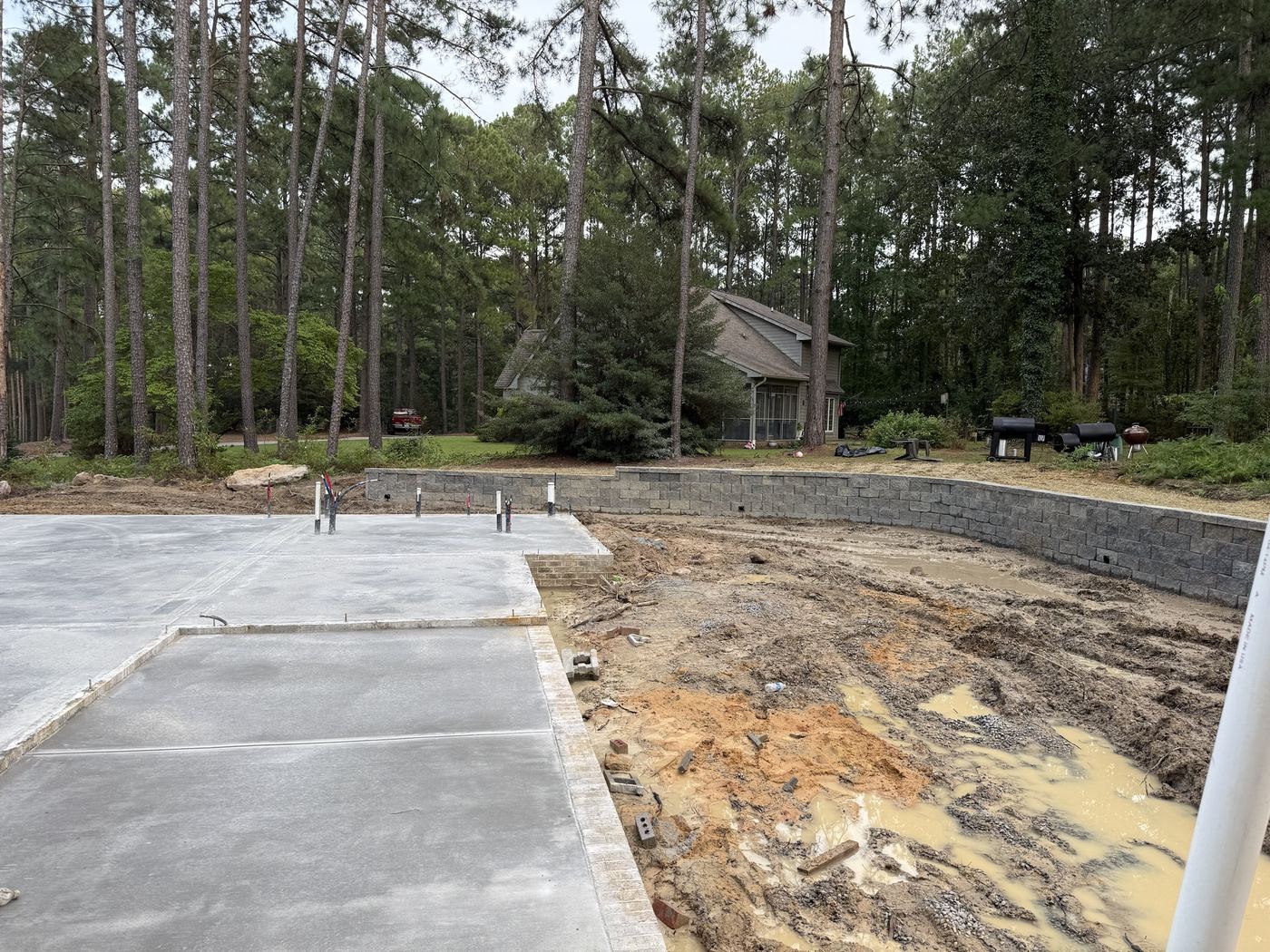 Segmental block retaining wall built for a new home, with drain outlets at the base.